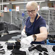 Leena Rieskaniemi leikkaa nahkakappaleita tuotannon alkupäässä Sievin Jalkineen tehtaalla.