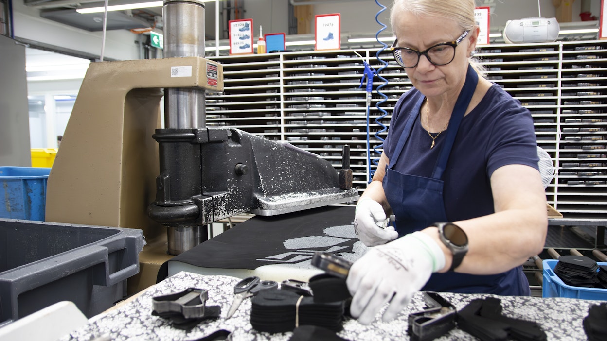Leena Rieskaniemi leikkaa nahkakappaleita tuotannon alkupäässä Sievin Jalkineen tehtaalla.