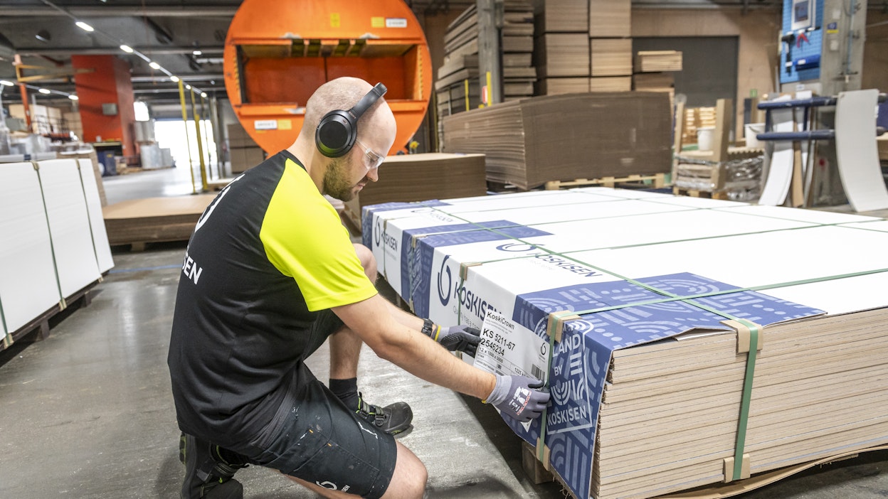 Niko Penttinen liimaa pakattuihin vanerinippuihin tarroja.