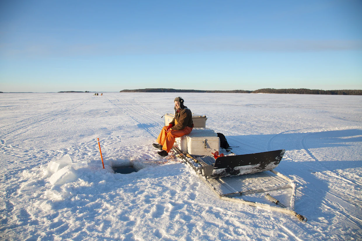 Kalastaja on ammatissaan luonnonolojen armoilla. Parhaimmillaan talvinen aurinko nostaa hymyn huulille rankan työn lomassa.