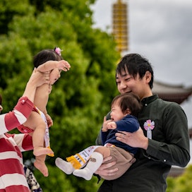 Japanilaisperhe leikki Sensoji-temppelin edustalla Tokiossa huhtikuun lopulla. Japanin hallitus rohkaisee Tokiossa asuvia ja siellä työssä käyviä muuttamaan harvemmin asutuille alueille noin 4  000–7  500 euron kannustimella. LEHTIKUVA/AFP. 