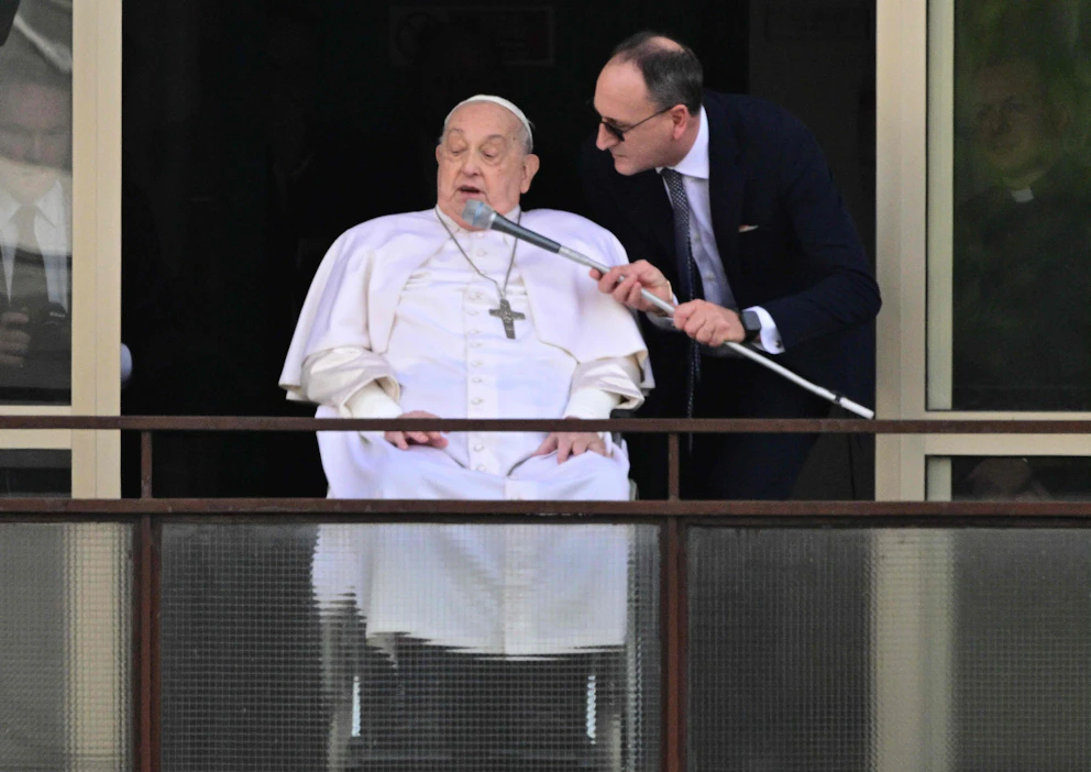 Pyörätuolissa istunut paavi Franciscus kiitti ennen lähtöään kaikkia terveydestään huolehtineita Gemellin sairaalan parvekkeelta Roomassa. LEHTIKUVA / AFP.