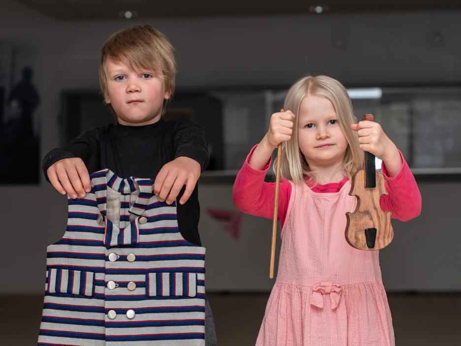Tiedotekuva: Hermanni Hakamäki ja Saima Havia ojensivat Kaustisen-puvun liivin ja lasten harjoitusviulun toimitettavaksi Meksikoon.