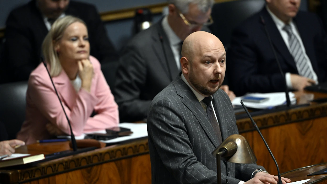 SDP:n Joona Räsänen (etualalla) sanoi, että sairaaloita ei pelasteta hurskailla lausumilla. Vasemmalla valtiovarainministeri Riikka Purra (ps.)