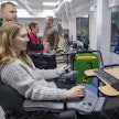 Hanna Haapanen harjoittelee kuormaamista ajokonesimulaattorilla Tampereen seudun ammattiopisto Tredun Kurun kampuksella. Lehtori Janne Ruokonen seuraa vieressä.