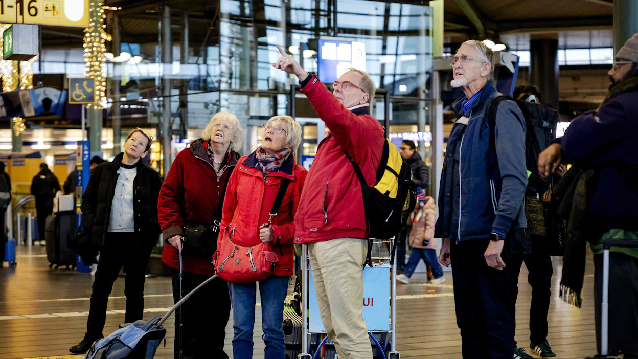 Matkustajat katsoivat tietoja lennoista Schipholin kansainvälisellä lentoasemalla Hollannissa sunnuntaina. LEHTIKUVA/AFP.