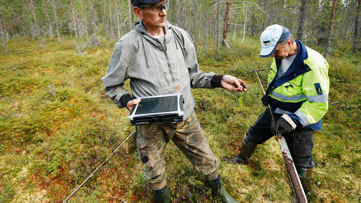 Inventoinneissa selvitetään soiden kasvillisuutta sekä turvekerroksen paksuutta ja rakennetta. Tutkimuspisteessä ovat näytettä kairaamassa tutkimusassistentti Ilkka Aro (vas.) ja kairamies Veikko Sieppi.