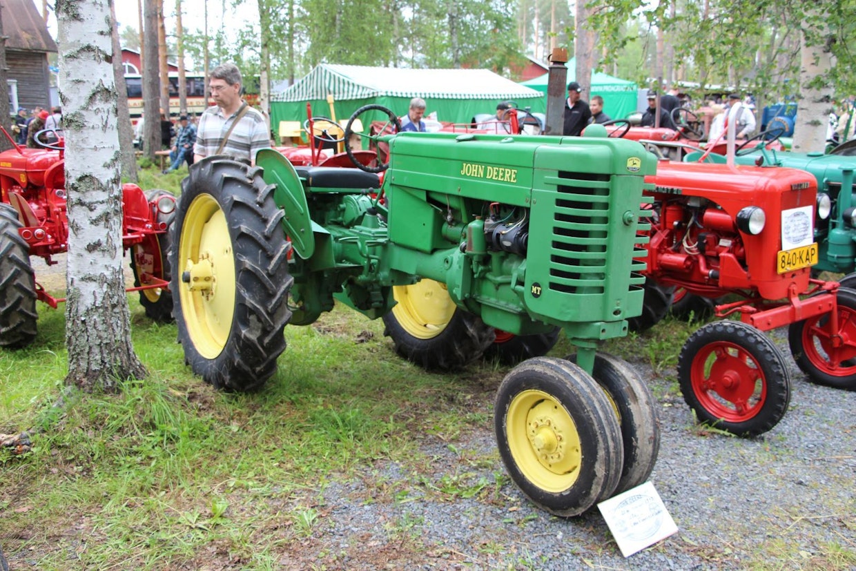 John Deere M oli merkin ensimmäisiä pystysylinterisiä traktoreita, jolla korvattiin vuodesta 1947 lähtien niin ikään pystysylinterinen pikkutraktori LA ja makaavasylinterinen H. 2-sylinterinen bensamoottori on 1,65-litrainen ja 21-hevosvoimainen, vaihteita on 4 eteen ja pakki. Kuvan riviviljelymallinen MT painaa suunnilleen 300 kiloa perusversiota enemmän eli 1 450 kg. (Oulainen)