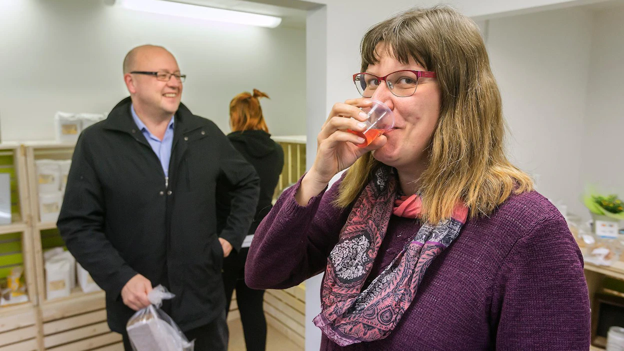 Kirsi Huhtala maistaa marjamehua, jota tarjotaan pop up -lähiruokakaupassa. Ostoksille on tullut Kurikan maaseutupäällikkö Reijo Hämäläinen (vasemmalla).
