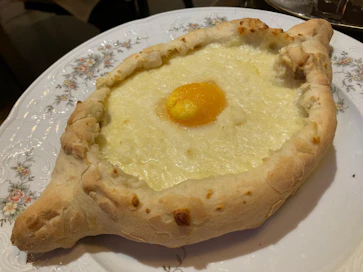 Hatsapuri voi olla myös veneen muotoinen. Se murretaan päästä ja leipäpalalla sekoitetaan muna juustoon ja syödään.