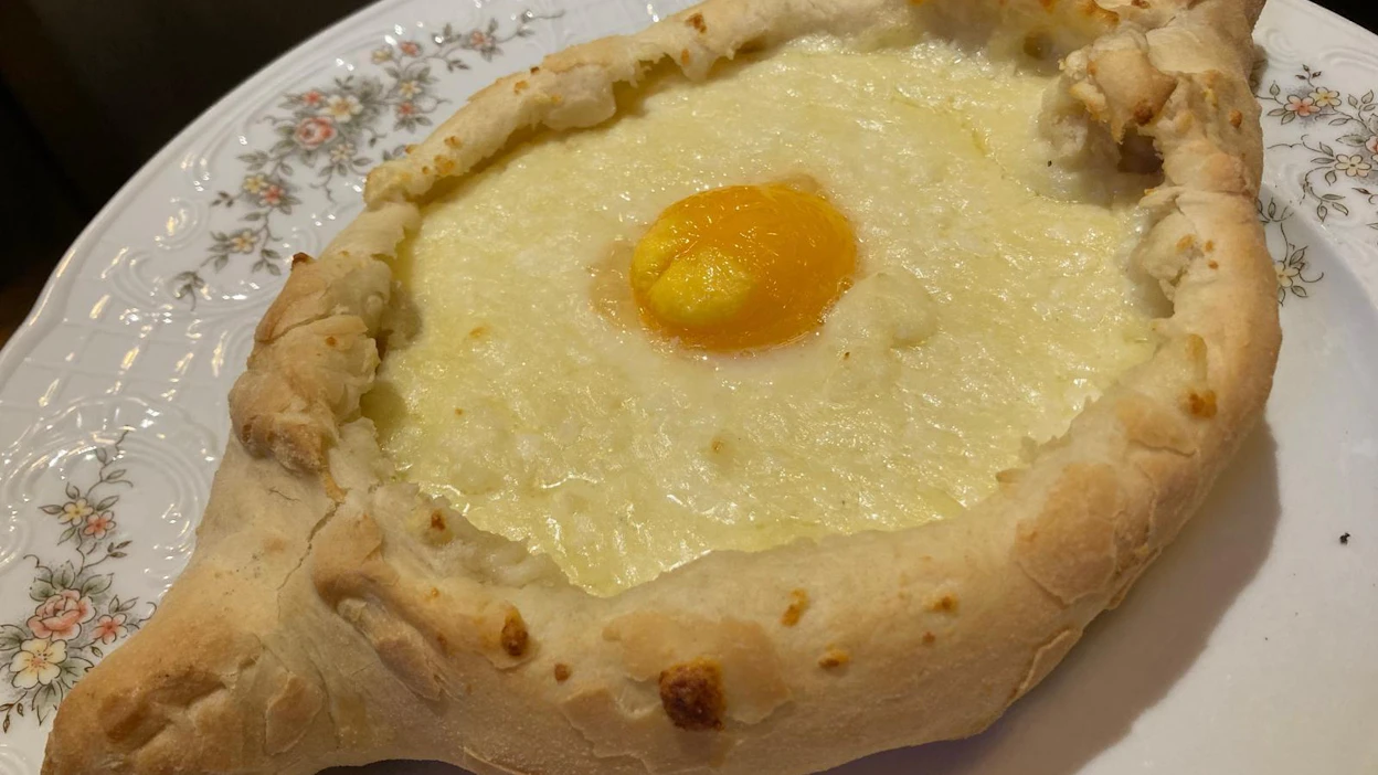 Hatsapuri voi olla myös veneen muotoinen. Se murretaan päästä ja leipäpalalla sekoitetaan muna juustoon ja syödään.