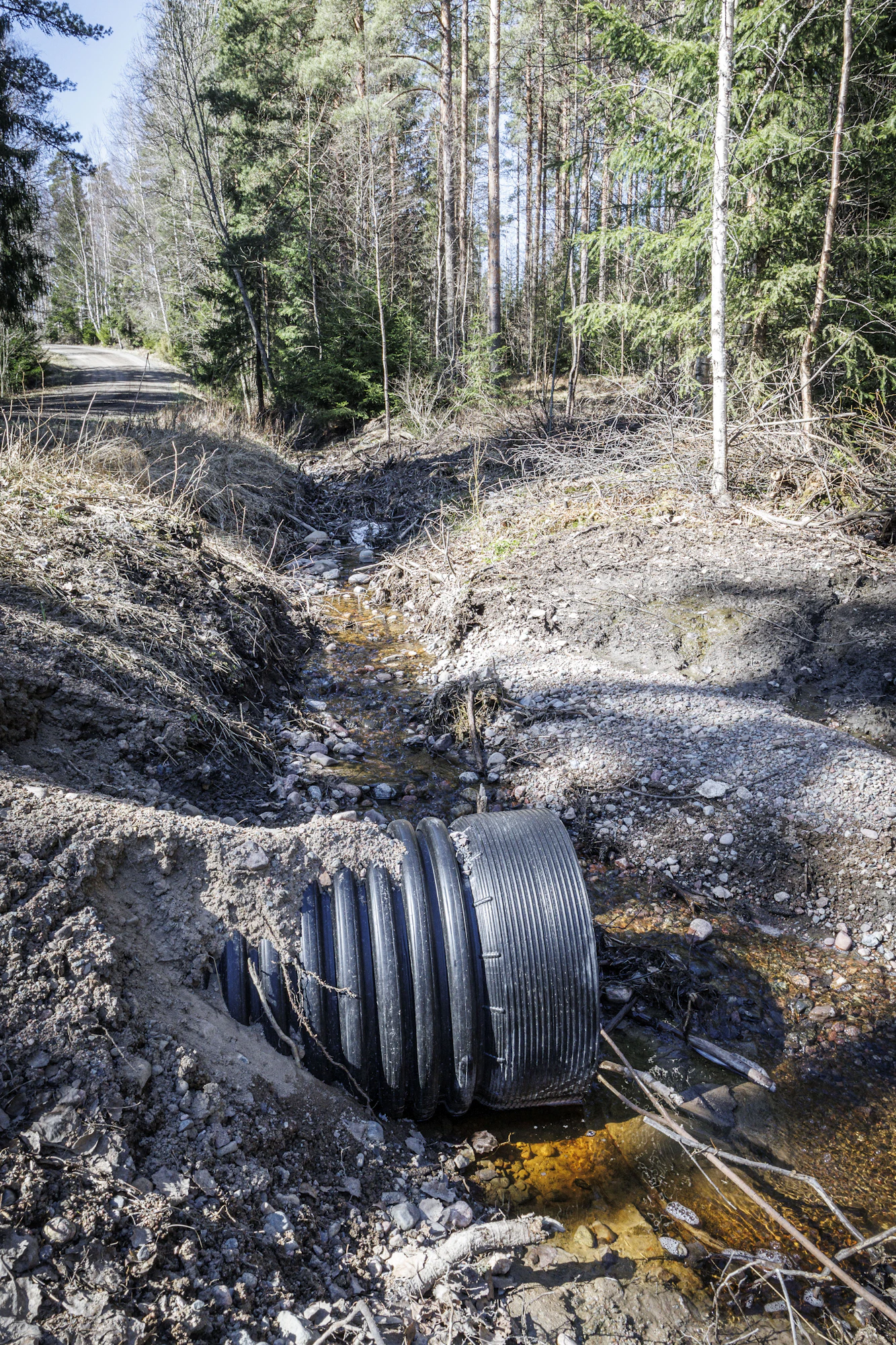 Viime vuoden elokuussa asennettu tierumpu ohjaa metsäojista valuvia vesiä tien ali pellon reunaan.