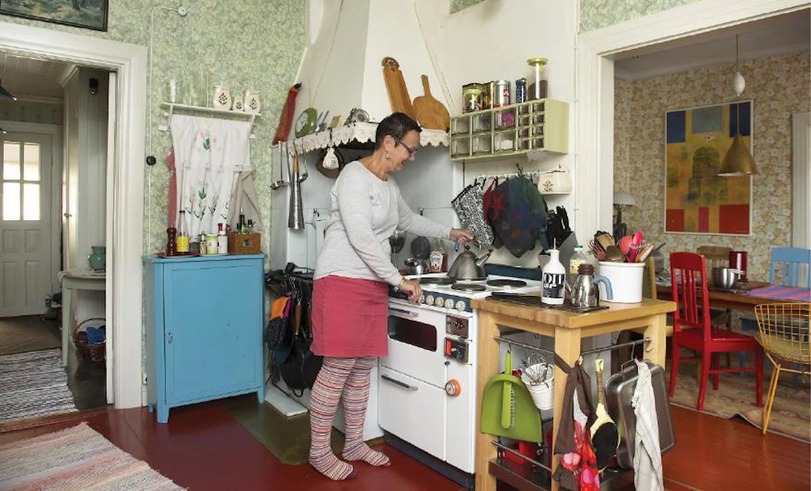 Keittiö on pieni. Kookas liesi on 1960-luvulta, siinä on kaksi uunia. Jääkaappi on 55-vuotias. ”Vaihdamme tavaroita vasta, kun ne lakkaavat toimimasta tai niitä ei voi korjata”, Tuulikki sanoo.