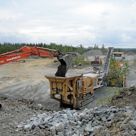 Murskattava kiviaines lastataan kaivurilla esimurskaimeen. Suuret, yli 800-milliset lohkareet erotellaan ja murskataan kaivurin hydraulisella vasaralla. Tuotantoon saadaan vauhtia vaihtamalla 25 tonnin kaivuri 40-tonniseen.
