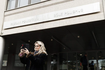 Kristillisdemokraattien kansanedustaja Päivi Räsänen otti matkapuhelimella itsestään selfien, kun oli maanantaina menossa kuulusteluihin Pasilan poliisitaloon Helsingissä. LEHTIKUVA / RONI REKOMAA