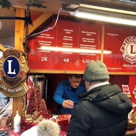 Tallinnan vilkkaalla joulutorilla myydään monenlaista  glögiä ja ihmiset kiertelevät mukit kädessä katselemassa kojujen tarjontaa.