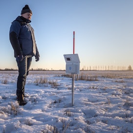 Viljelijä Kari Alasaari katsasti joulukuussa 2021 pellollaan olevan mittarin, joka kertoo muun muassa ilman ja maan lämpötilan, kosteuden ja sähkönjohtavuuksia.