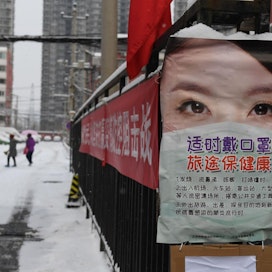 Pekingissä tietoa koronavirukselta suojautumisesta levitetään muun muassa julisteissa. LEHTIKUVA / AFP