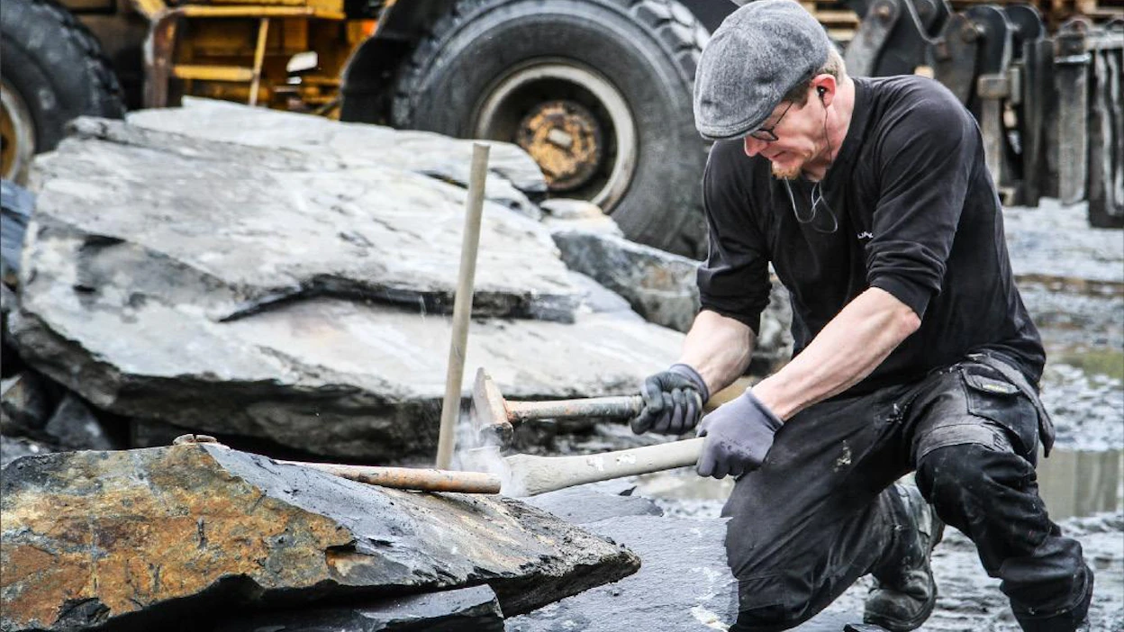 Heikki Kontkanen näyttää, miten kiveä lyödään otsaan ja miten yllätyksellisesti tumma kiilleliuskekivi saattaa lopulta haljeta. Kivimies ei kuulemma tule koskaan valmiiksi ammatissaan. Lari Lievonen