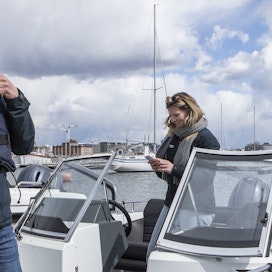 Venepalvelu Skipperin markkinointijohtaja Jussi Koskinen ja perustaja Anna-Leena Raij valmistautvat vesille. Veneeseen kirjaudutaan kännykällä ja veneissä on liivit.