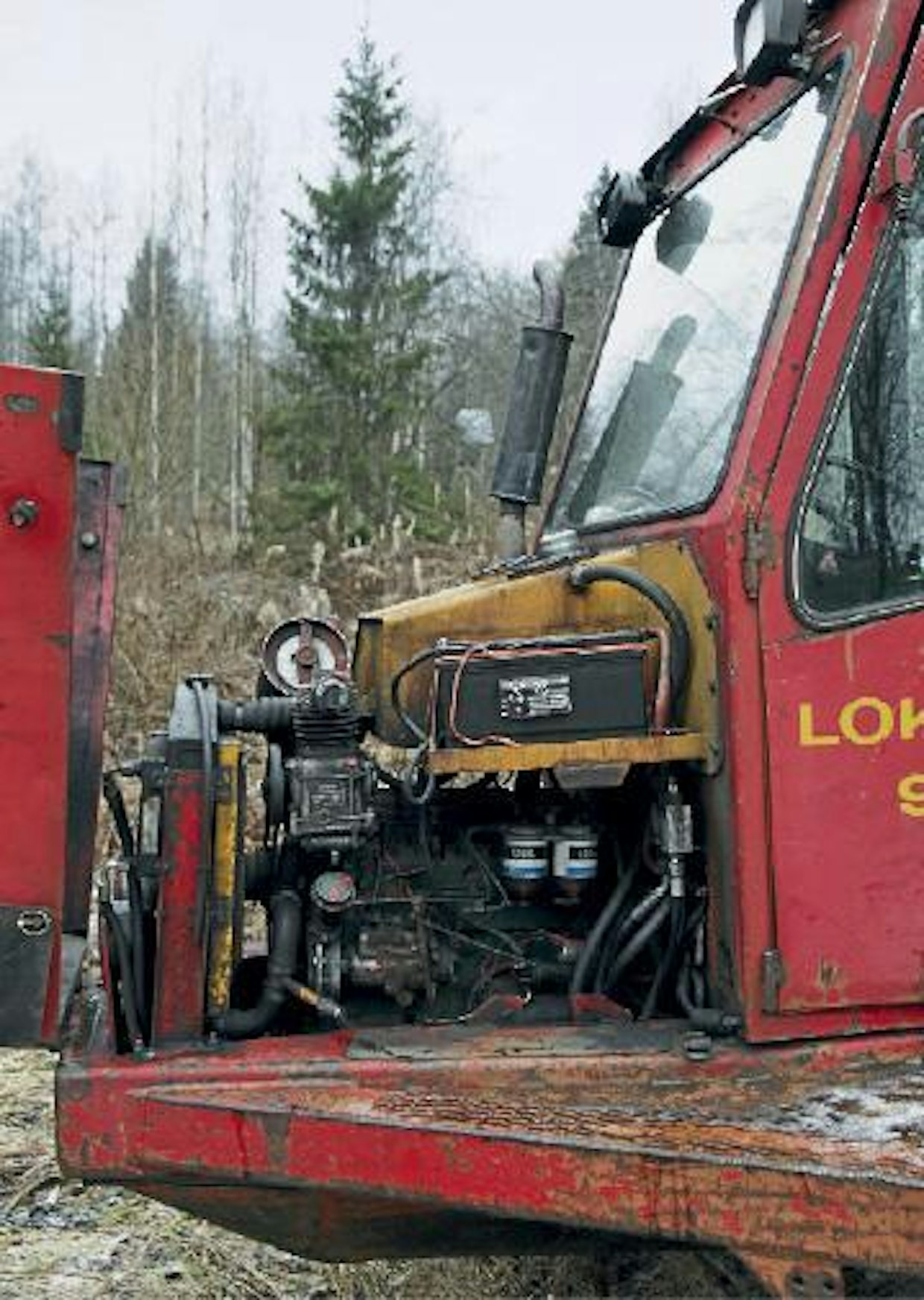 Klassinen nelipyttyinen Perkins piiloutuu hydraulisäiliön alle. Eturunkopalkkeihin on suunniteltu kannelliset työkalukotelot, ja akku on lämpimässä konehuoneessa. Uudemmissa malleissa akut olivat ohjaamon takana kylmässä. Pidempien johdotusten vuoksi talviaamujen starttaukset saattoivat olla nahkeita.