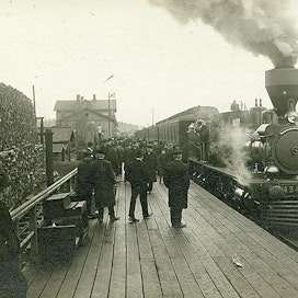 Riihimäen rautatieasema.  Aseman edessä laiturilla matkustajia ja raiteella höyryveturi Sk3, nro 434. Kuva on arviolta vuodelta 1907.