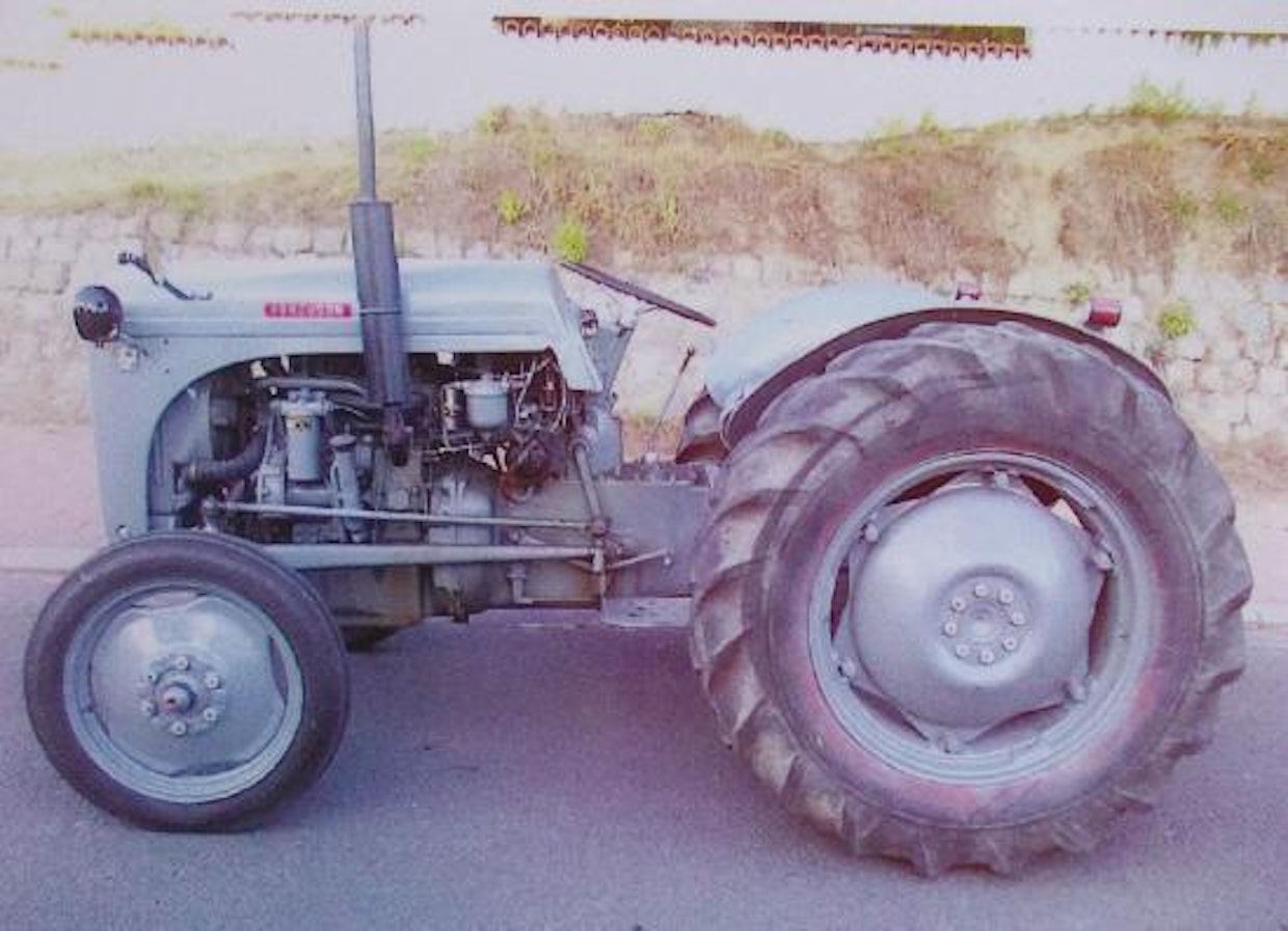 Jälkidieselöity pikkuharmaa Perkins P3TA-moottorilla. Koneessa on ketjuvetoinen jakopyörästö ja paljon ulkopuolisia putkistoja.