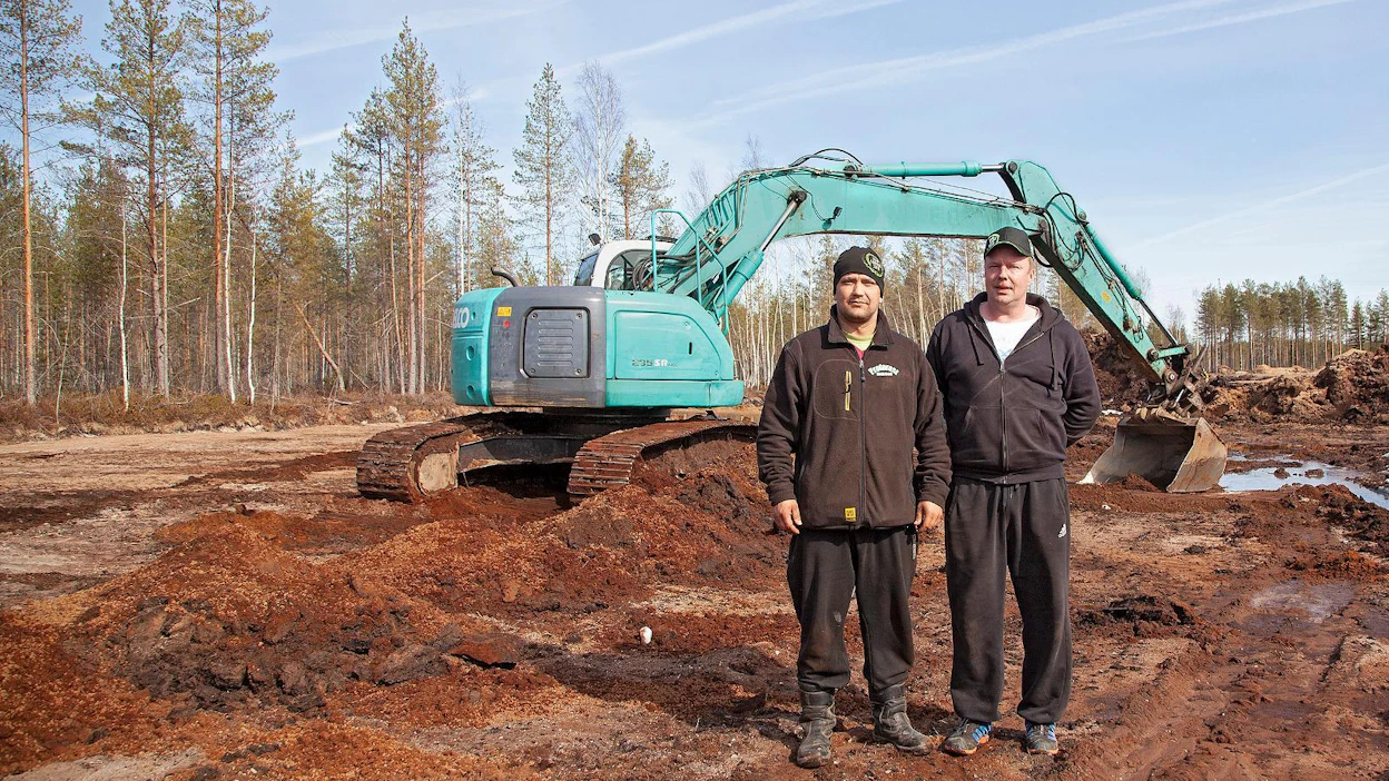 Markku Laitinen viimeistelee parkkipaikan laajennusta taustalla kaivinkoneen puikoissa. Juhana Männikkö (vas.) ja Tomi Ruuska ovat Proforest-messujen muut puuhamiehet.