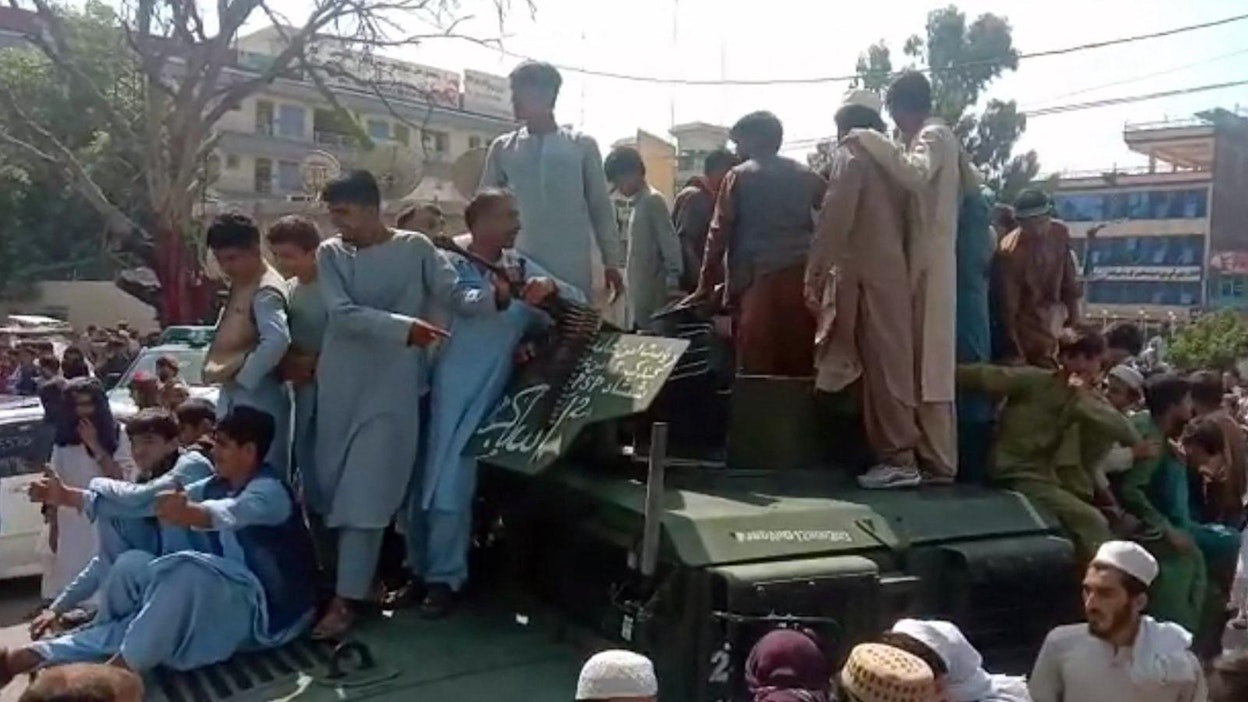 Jalalabadissa Talebanin taistelijat ja paikalliset asukkaat istumassa Afganistanin armeijalta saaliiksi saadun Humvee-sotilasajoneuvon päällä tänään. Kuvakaappaus AFPTV:n videosta. Lehtikuva/AFP
