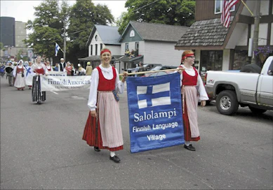 Amerikansuomalaisnuoret kantavat paraatissa opinahjonsa julistetta halki Hancockin. veli vihonen