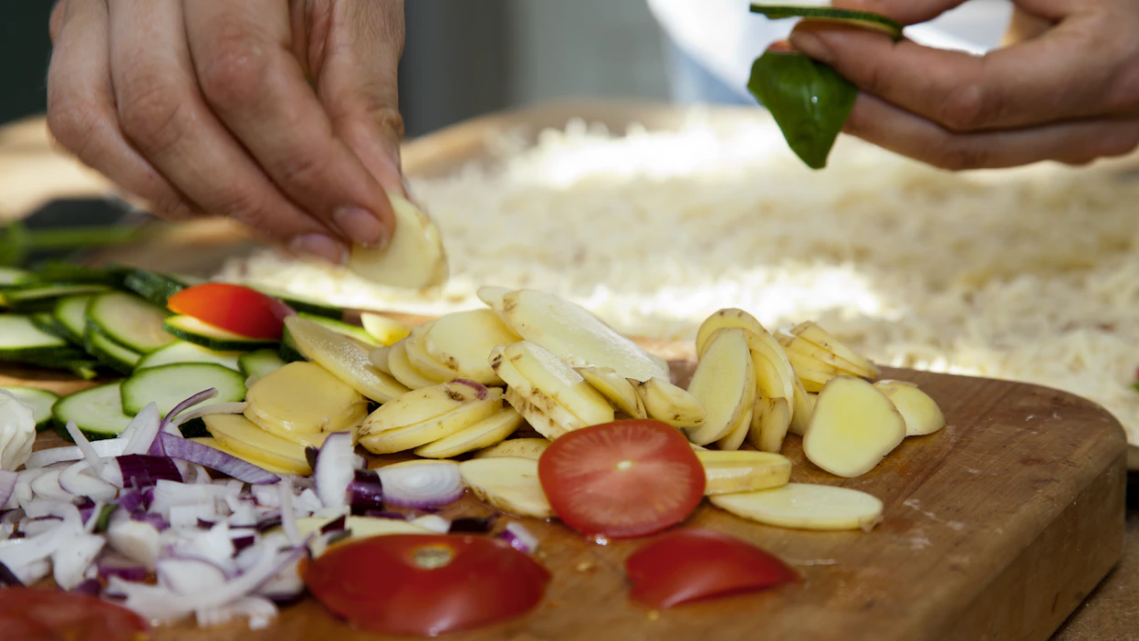 Peruna sopii myös pizzaan. Edellisen päivän keitetyt perunat lohkotaan ohuiksi siivuiksi.