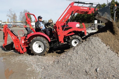 LH-Osan Hannu Ryhänen näyttää mallia, kuinka suurempi Dongfeng puskee kasalle. Nelivedon ja kaivulaitevarustuksessa olevan traktorin lähes kahden tonnin paino varmistavat hyvän puskutehon. Kauhan saa helposti täyteen mursketta.