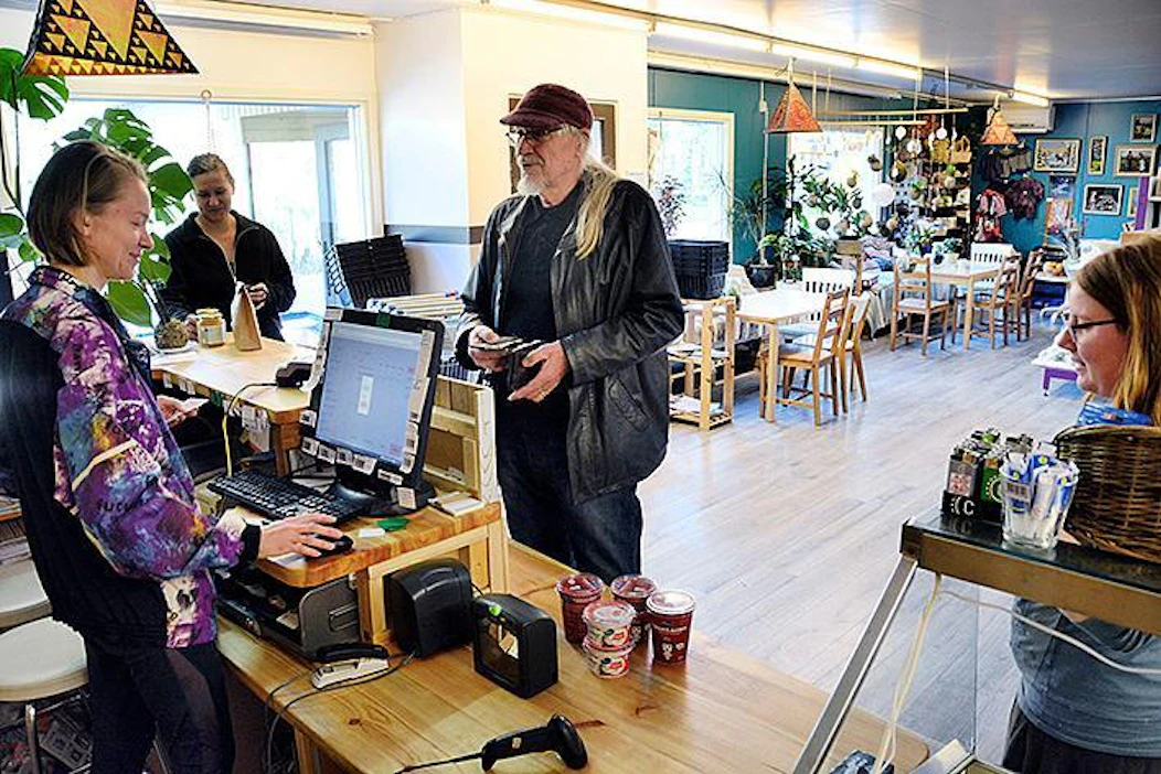 ”Kaupalla on niin kiva tunnelma, että tulen tänne usein ihan vain senkin vuoksi”, kehuu yhteisökylässä savipölkkyrakenteisessa talossa asuva Veikko Aro-Heinilä, joka kuuluu osuuskaupan vakioasiakkaisiin.
