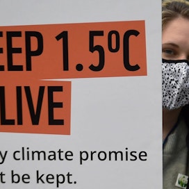 Glasgow&apos;n ilmastokokouksen viimeisenä virallisena päivänä perjantaina neuvottelut monista keskeisistä kysymyksistä olivat vielä vailla ratkaisua. Mielenosoittaja piteli ilmastolupauksista muistuttavaa kylttiä. LEHTIKUVA / AFP