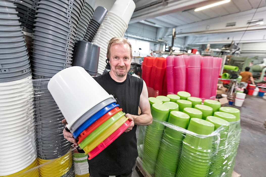 Muoviämpäreitä saa likimain kaikissa sateenkaaren väreissä, Vesa Mikkonen näyttää.