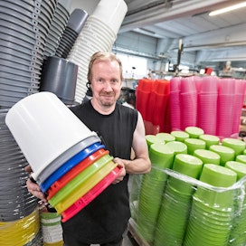 Muoviämpäreitä saa likimain kaikissa sateenkaaren väreissä, Vesa Mikkonen näyttää.