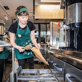 Chloe Ashworth pakkaa ResQ ruokaa Robert&apos;s Coffeessa Helsingissä. Sovellus on vähentänyt kahvilan myytävien tuotteiden hävikin lähelle nollaa.