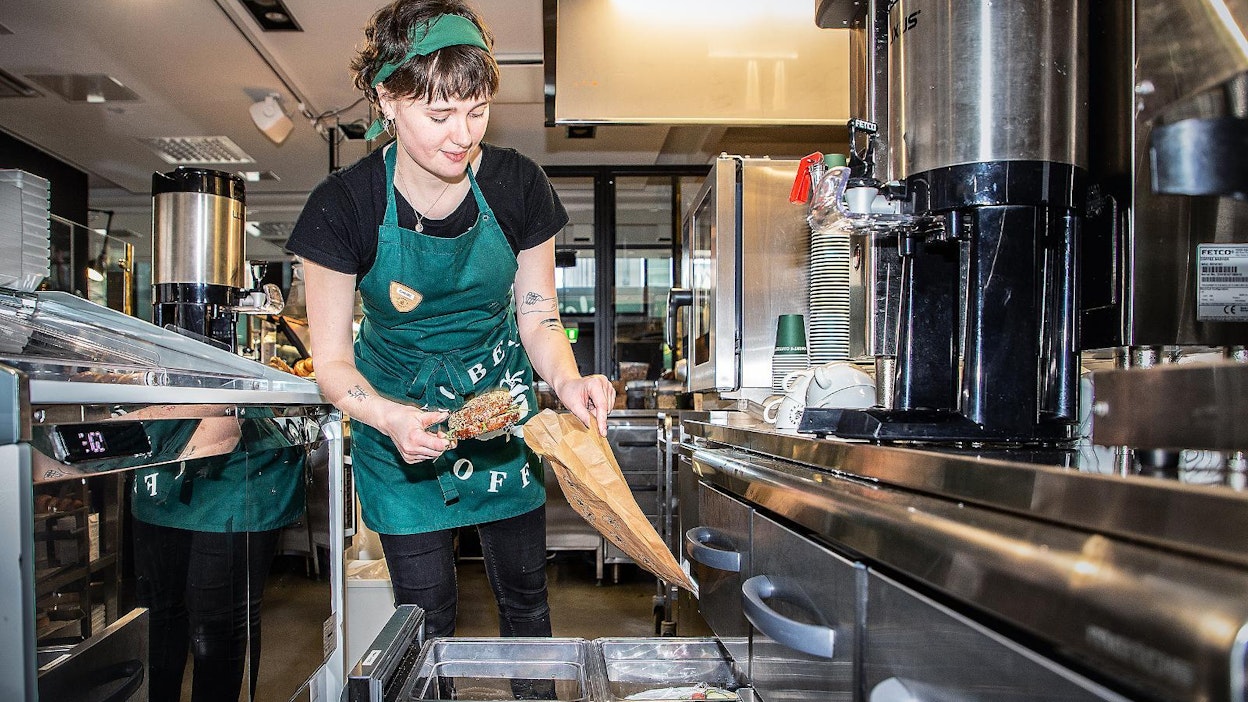 Chloe Ashworth pakkaa ResQ ruokaa Robert's Coffeessa Helsingissä. Sovellus on vähentänyt kahvilan myytävien tuotteiden hävikin lähelle nollaa.