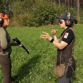 Haulikkokouluttaja Marianna Saren (oik.) näyttää hyvän ampuma-asennon Tuuli Blommandahlille.