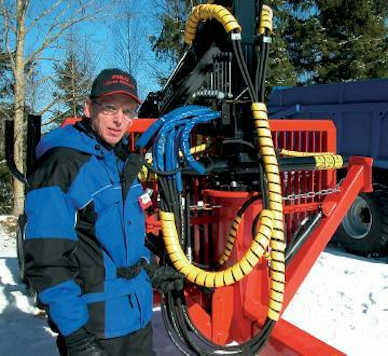Kuormaimella varustettu Piko-metsävaunu. Traktoriin liitettynä kuormaimen ohjauslaitteisto asennetaan ohjaamoon. Toimitusjohtaja Seppo Pirttinen esittelee.