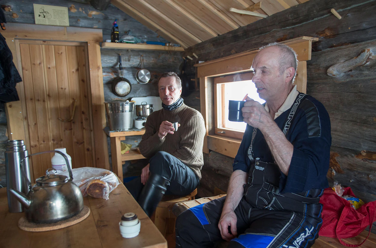 Artan kämpän rakentajat ja huoltomiehet Kari Tikkanen ja Urpo Karppinen juovat tulokahvit ennen polttopuiden tekoa.