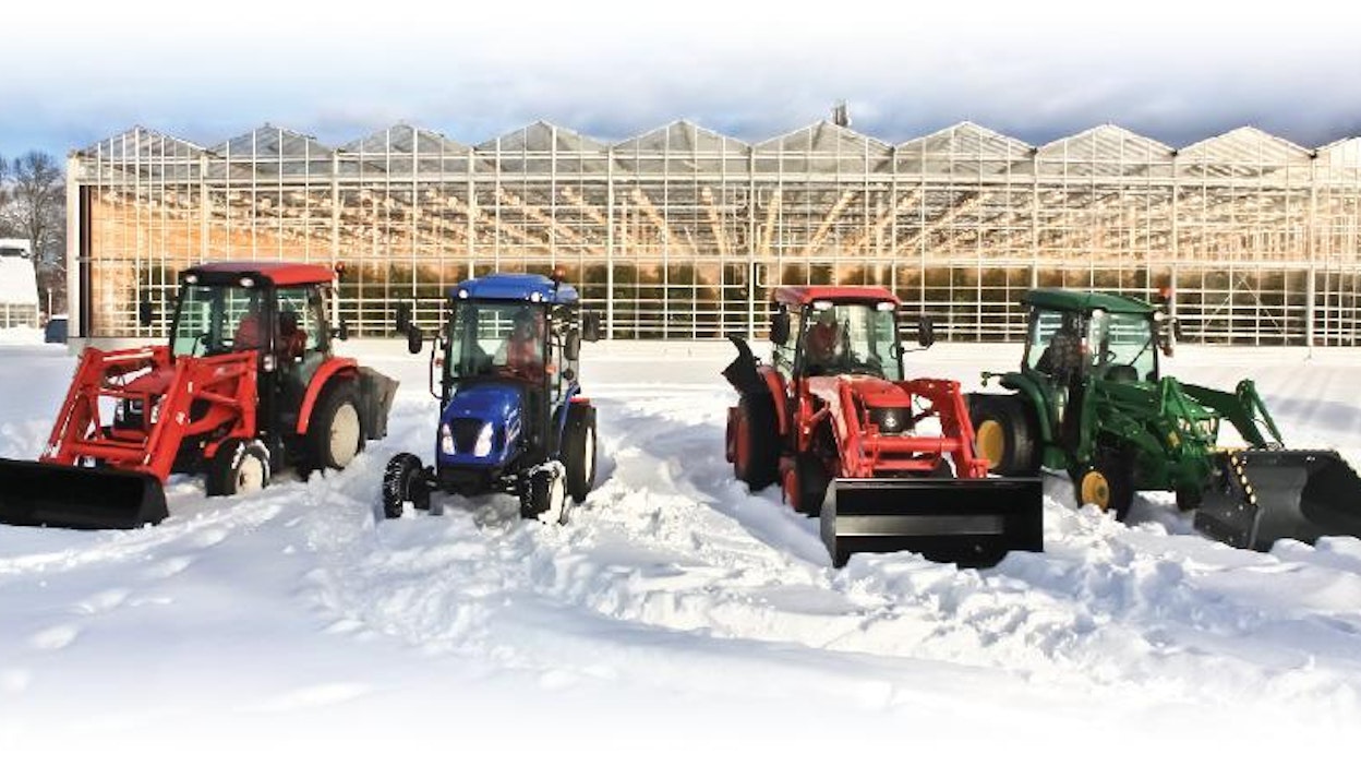 Kaikki testin traktorit yhteiskuvassa Lepaan  oppilaitoksen uusimman kasvihuoneen edessä.