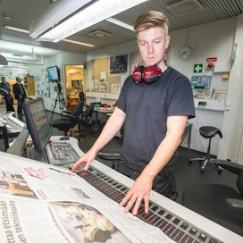 Lehtiseppien painaja Miikka Juvonen tarkistaa lehden värisävyjä ja säätää värin määriä tarvittaessa.