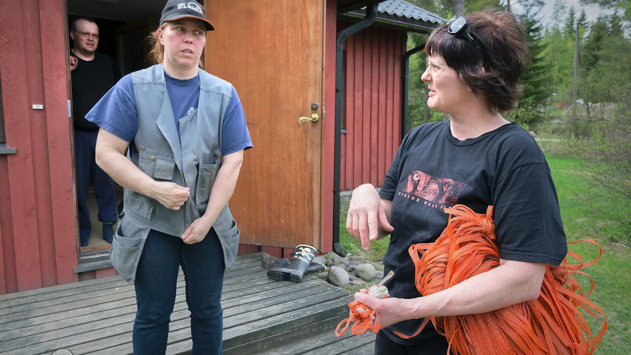Satu Kumpulainen (vasemmalla) antaa työohjeita Luonto-Liiton talkoisiin saapuneelle mäntsäläläiselle Venla Karttuselle. Isäntä Pasi Kumpulainen kuuntelee taustalla.