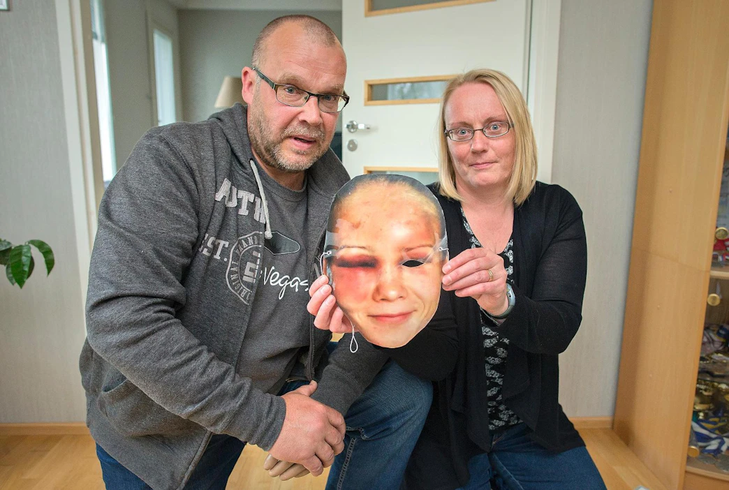 Pertti ja Päivi Olli esittelevät tuttavalta saatua Petra Olli -kannustusmaskia.