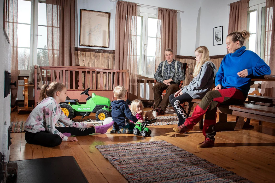 Vaikka Kekäläisten perheessä monen muun lapsiperheen tavoin korona-aika on ollut erityistä härdelliä, arjessa vaalitaan myös leppoisia hetkiä. Veera (vas.), Kalle, Helmi, Juha, Liisa ja Anne Kekäläinen perinteiseen yläsavolaisen malliin tehdyn talon tuvassa.