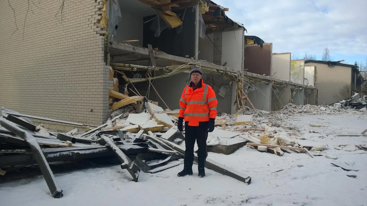 Raimo Flink entisen kotinsa edustalla. Tampereen Härmälässä sijainneessa taloyhtiössä oli 36 asuntoa, jotka purettiin kaatopaikan läheisyydestä.
