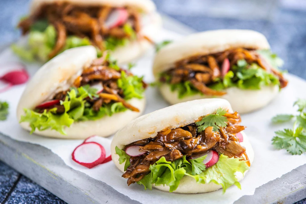 Bao-sämpylöiden täyte näyttää nyhtöpossulta, mutta on nyhdettyä ja maustettua kuningasvinokasta. Bao-sämpylöitä löytyy kauppojen leipäosastoilta.