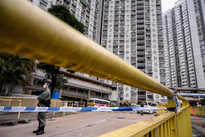 Poliisi vartioi Hongkongissa taloa, josta evakuoitiin ihmisiä koronavirustartuntojen takia.