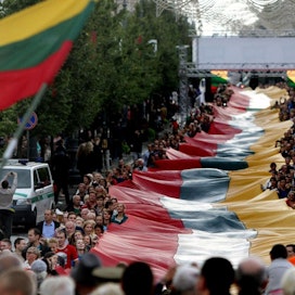Liettualaiset juhlivat vuonna 2014 ihmisketjun 25-vuotispäivää kilometrin pituisella Liettuan lipulla. Lehtikuva/AFP